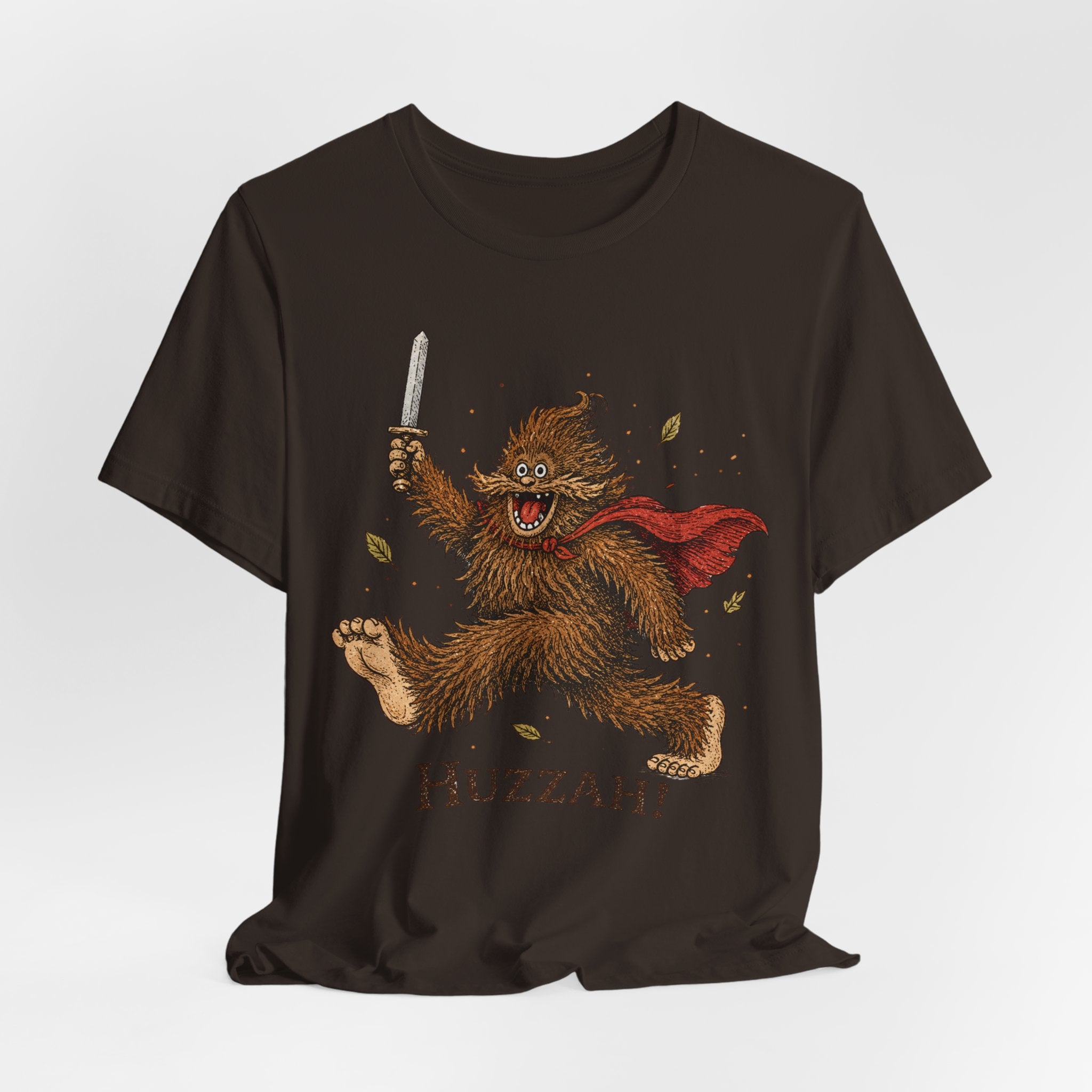Huzzah Bigfoot T-Shirt in Brown - young Bigfoot sword cape charging graphic tee, Barely Outdoorsy