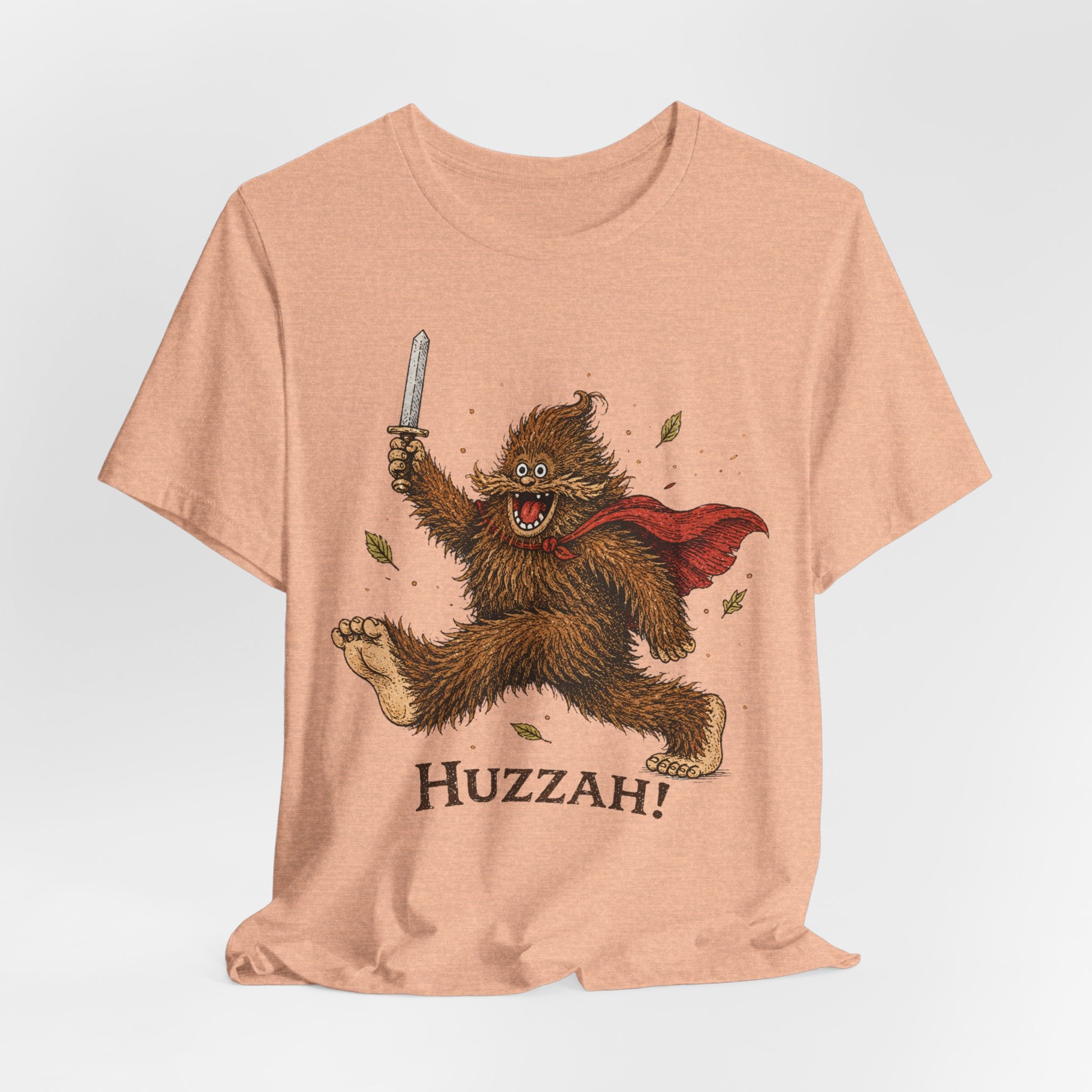 Huzzah Bigfoot Tee in White detail - young Sasquatch sword cape huzzah close-up graphic