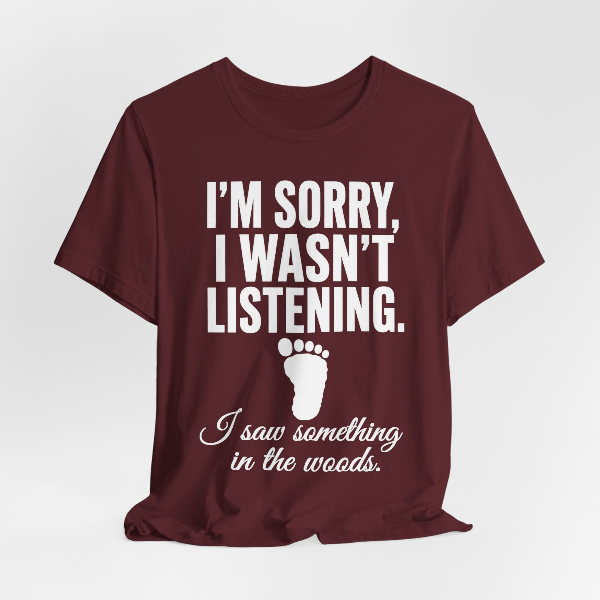 I Saw Something In The Woods T-Shirt in Maroon - bold white text Bigfoot footprint graphic tee, Bella Canvas 3001