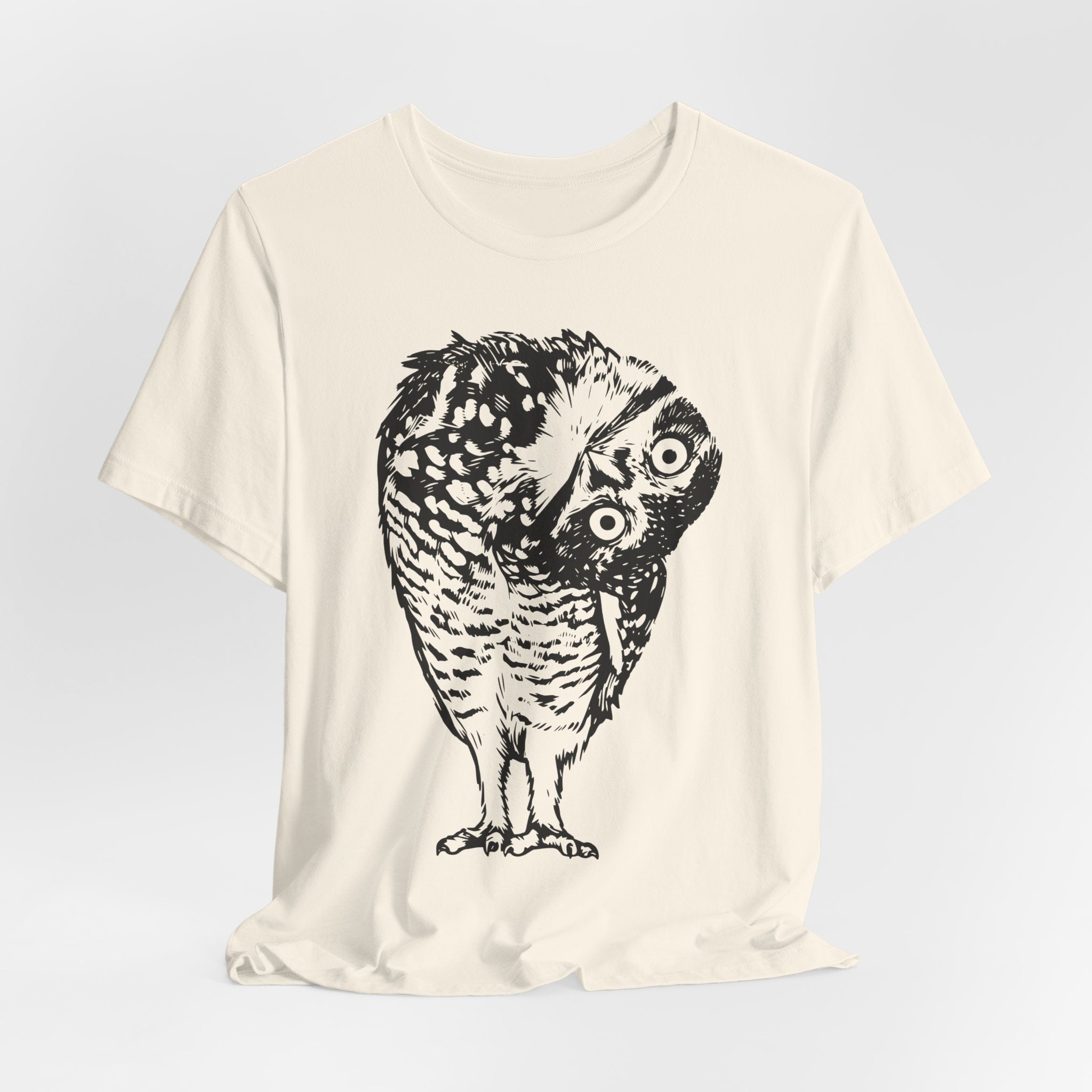 Close-up of shocked owl illustration with wide eyes and head rotated backward on white cotton tee