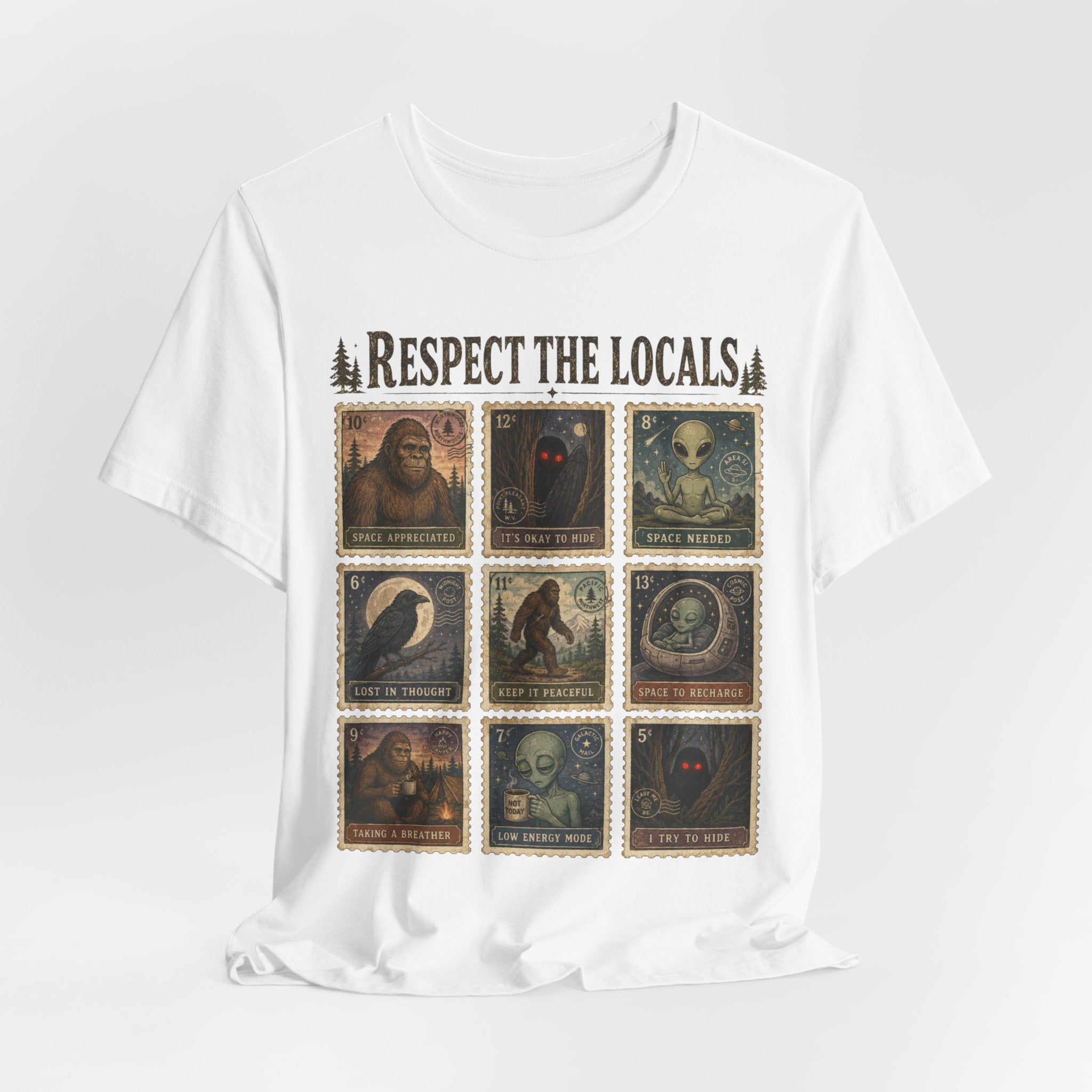 White unisex t-shirt with vintage postage stamp grid graphic featuring Bigfoot alien raven and shadow cryptids with captions Respect The Locals, Bella Canvas 3001